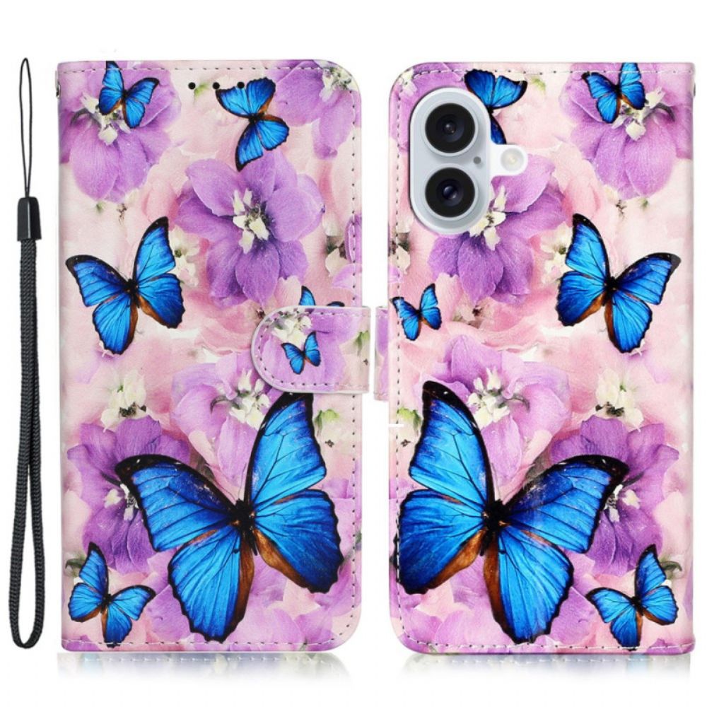 Lederhüllen iPhone 16 Blaue Schmetterlinge Und Lila Blumen Mit Riemen