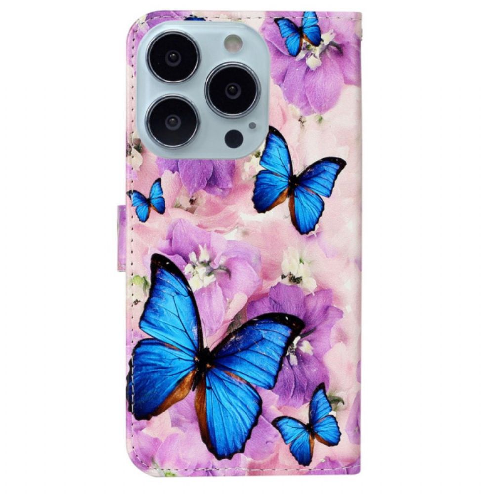 Lederhüllen iPhone 16 Pro Handyhülle Blaue Schmetterlinge Und Lila Blumen Mit Riemen